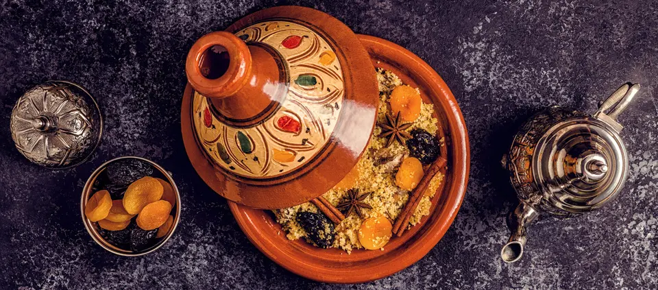 A tagine served beside a silver teapot