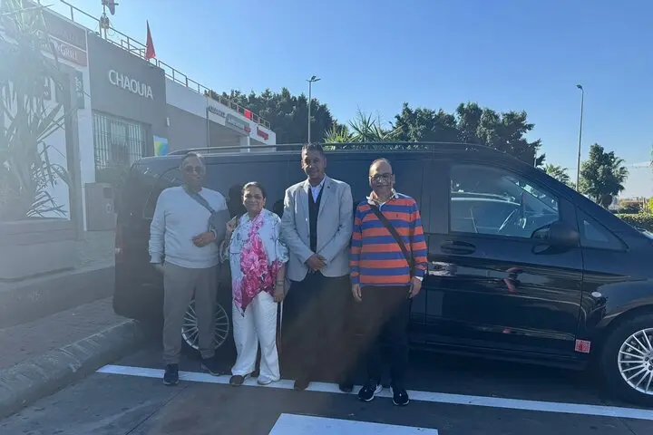 Guests with their driver beside the vehicle