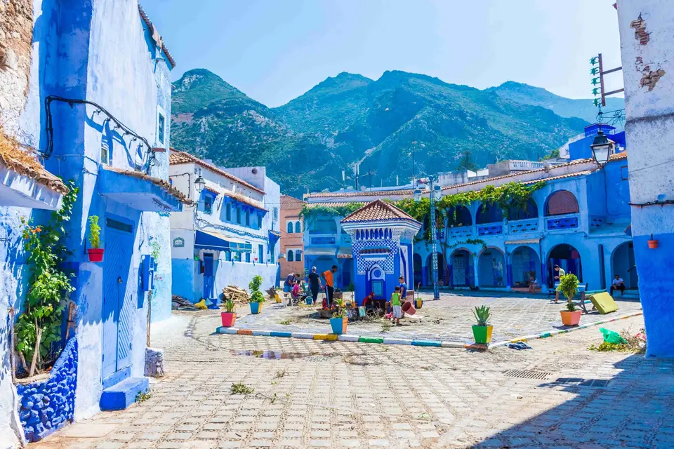 A square in Chefchaouen's blue medina, the Rif behind