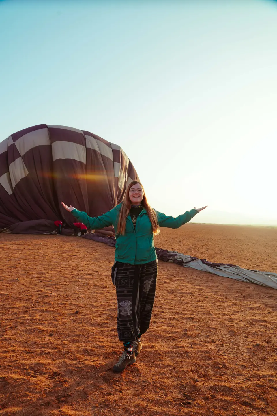 A guest in front of a balloon being inflated at dawn