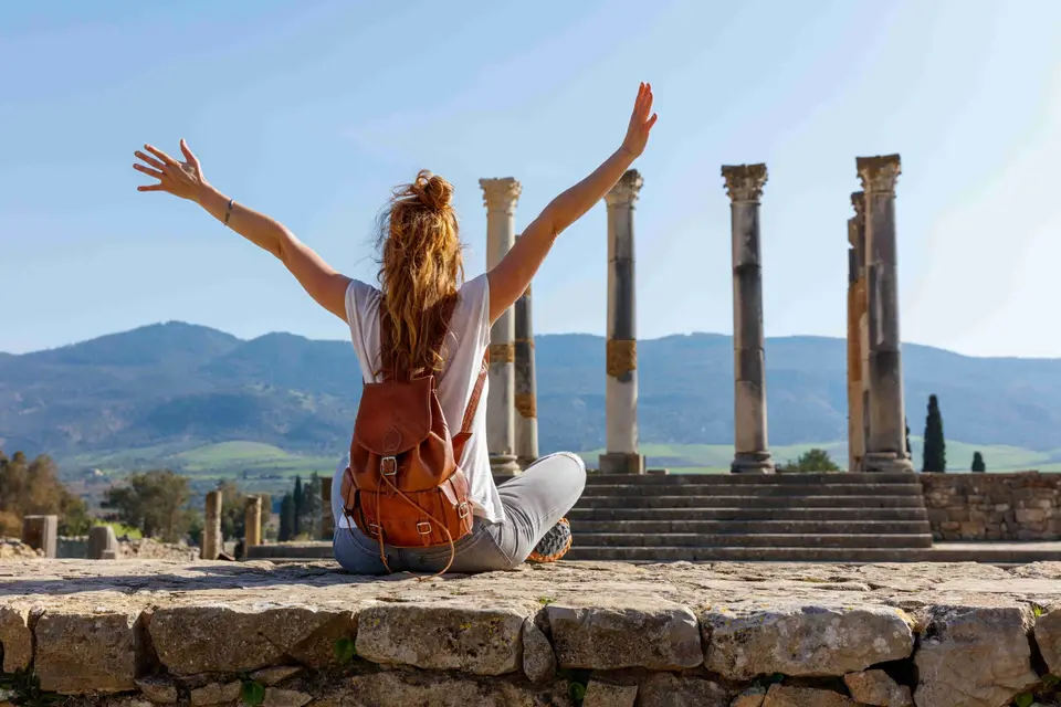 A traveler facing the Roman columns of Volubilis
