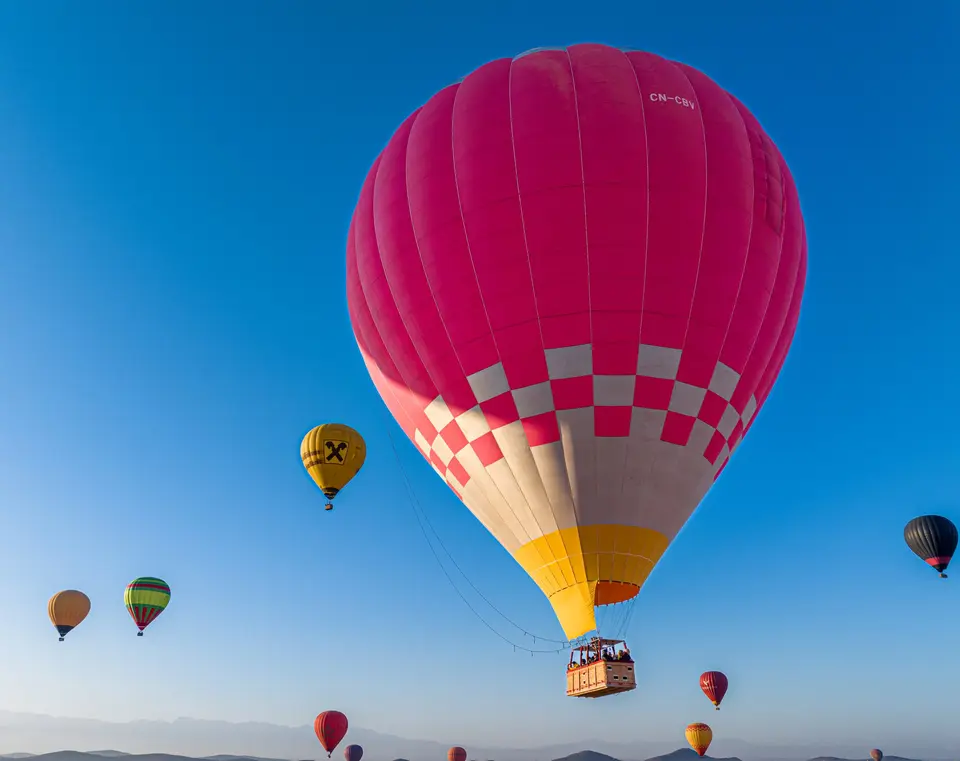 A pink balloon rising into a clear sky near Marrakech