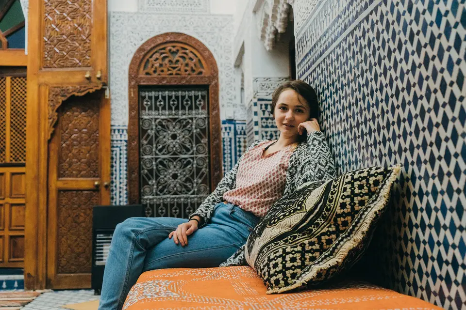 A traveler resting in a tiled riad courtyard