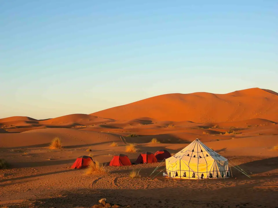 A tent among the dunes of Erg Chebbi at dusk